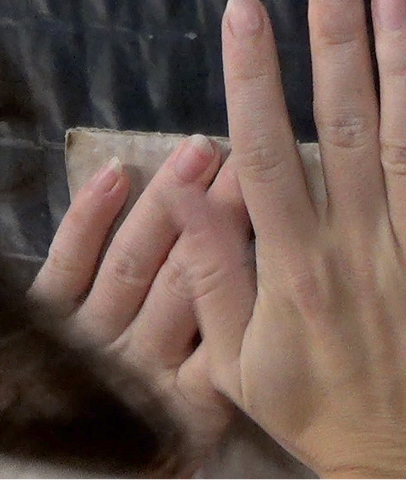 Mans apretant un bloc de fang contra la paret